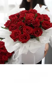 Detail of red roses wrapped in premium white pearl silk paper and round gift box