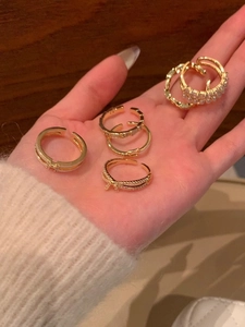 Detail shot of five gold-plated rings featuring bowknots, pearls, and sparkling crystals