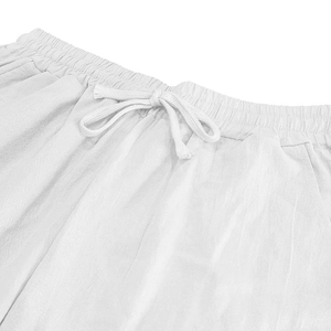 Detail of white linen trousers featuring elastic waistband and adjustable drawstring