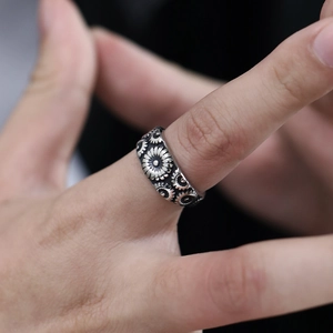 Macro shot of stainless steel wide ring featuring vintage daisy floral embossed patterns
