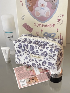 Detailed view of purple leopard print storage bag with zipper and branded fabric label