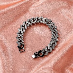 Bracciale Cuban argento hip hop con diamanti incastonati su elegante sfondo di seta