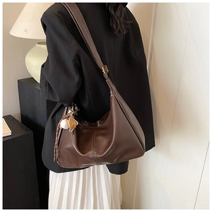 Detail of dark brown PU leather tote with adjustable strap and decorative charms