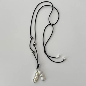 Detail of silver peanut pendant with white pearls on a black cord necklace