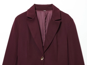 Detail of burgundy women blazer showing shoulder pads, lapel, and single button closure