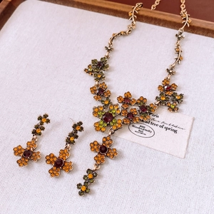 Detailed macro view of vintage flower jewelry set with colorful crystals and bronze base