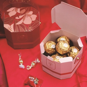 Elegant hexagonal wedding candy gift boxes in red and pink with golden patterns