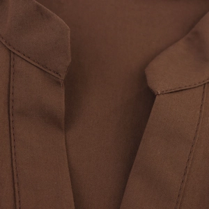 Close-up of the woven fabric texture and stitching details on a brown sleeveless dress