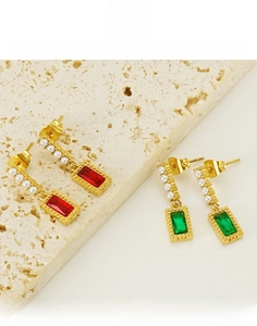 Detail of vintage square red and green zircon earrings with pearls in gold finish