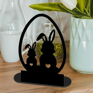 Detailed view of black rabbit and egg shaped acrylic desk ornament on wooden table
