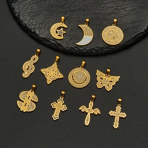Golden 18k plated pendants set with rhinestones on a dark textured stone surface