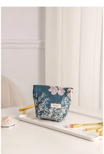 Close-up of jacquard floral cosmetic bag with pink flower patterns and petal zipper pull