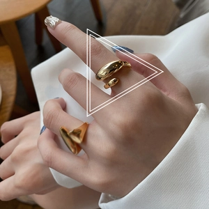 Detail of gold-plated irregular open rings showing minimalist French style jewelry on finger