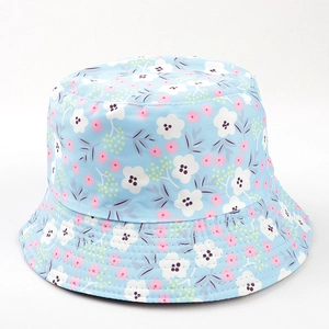 Détail d'un chapeau de soleil bleu clair en coton avec imprimés floraux roses et blancs fins