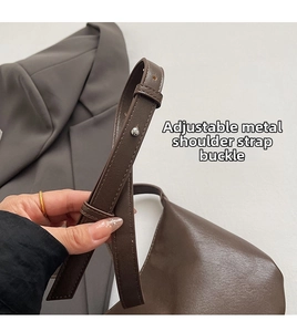 Detail of adjustable leather strap with silver buckle on a vintage brown shoulder bag