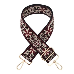 Détail de la bandoulière jacquard bohème bordeaux et noire avec mousquetons dorés
