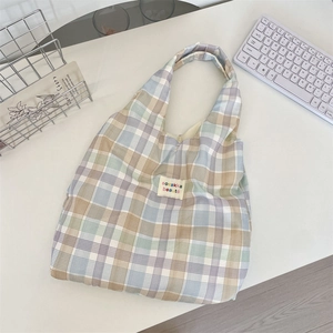 Detail of multi-color plaid tote bag with woven label on canvas fabric