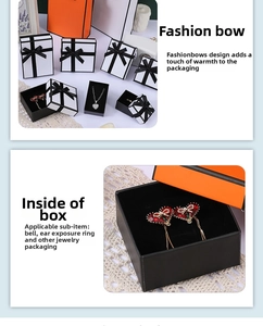 Detail view of orange jewelry gift box and matching carrier bag with black bow accent