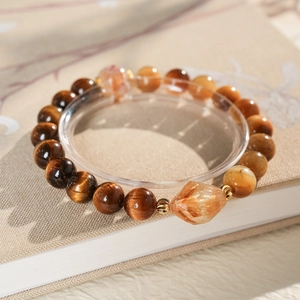 Macro detail of tiger eye stone bracelet with amber gemstones and gold metal spacers