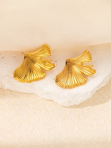 Détail macro de boucles d'oreilles feuille de ginkgo dorée avec textures réalistes