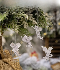 Detailed view of clear acrylic angel ornaments with silver wings on Christmas tree branches