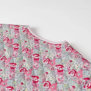 Detail of floral quilted jacket fabric with tie-up V-neck and striped trim design