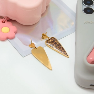 Detail showing leopard print heart earrings with a gold-plated polished metal finish