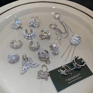 Detailed collection of silver ear cuffs and star zircon jewelry on a beige tray