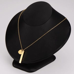 Elegant gold heart and vertical bar pendant necklace on a minimalist black display