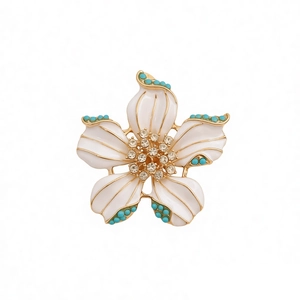 Broche fleur vintage en émail blanc avec bords dorés, perles turquoise et cristaux brillants