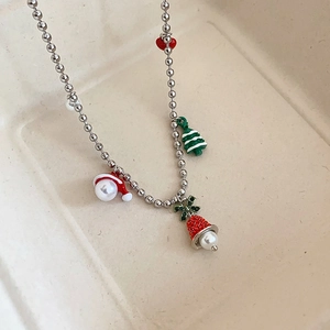 Detail of Christmas tree and bell pendant with pearls and red stones on a silver chain
