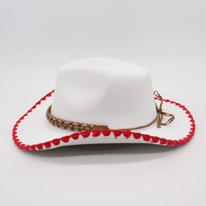 Detail of cream western cowboy hat featuring red wavy stitching and beaded band decoration