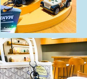Close-up of camouflage toy jeep and small luxury tote bag with yellow star embroidery