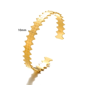 Detail view of 10mm wide gold stainless steel open cuff with textured geometric pattern