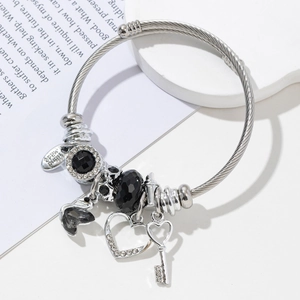 Silver stainless steel bangle with swan and heart charms on minimalist white background