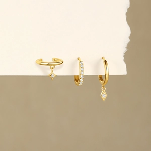 Detailed view of gold S925 silver star pendant and diamond rhombus hoop earring set