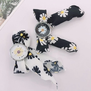 Detailed view of floral daisy fabric ribbon watches with black and white bow straps