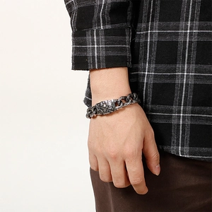 Detail of vintage skull clasp and interlocking link chain on male model's wrist