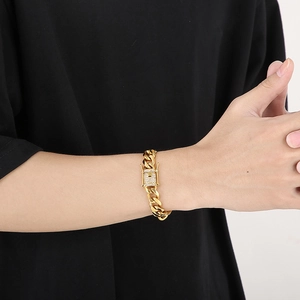 Close-up of gold Cuban link bracelet with diamond-encrusted clasp on male wrist