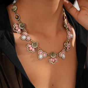 Close-up of vintage gold flower necklace with pink resin stones and crystal rhinestones