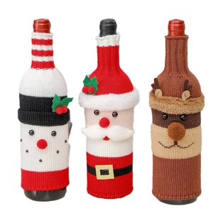 Three Christmas knitted wine bottle covers featuring Santa Claus, snowman and reindeer designs