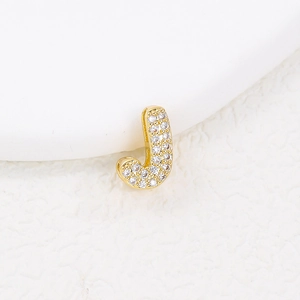 Close-up of golden letter J pendant featuring micro-pave white zircon stones