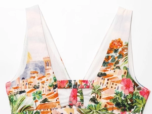 Close-up of deep V-neckline on floral print midi dress featuring Mediterranean motifs