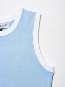 Détail d'un haut en maille bleu clair avec bordure blanche contrastante au col et emmanchures