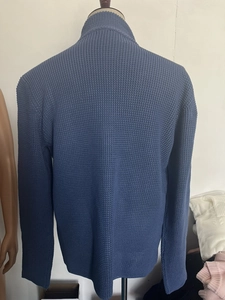 Close-up of deep blue waffle knit texture on a men's stand-collar cardigan sweater