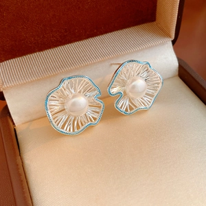 Detail of silver flower stud earrings with light blue enamel edges and white pearls in a box