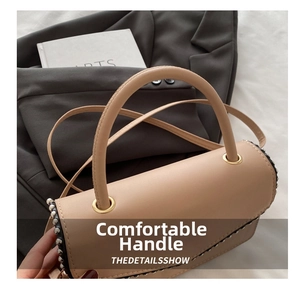 Detail view of the elegant beige handbag with silver stud trim and a rounded handle