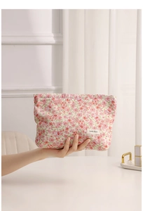 Close-up of pink floral fabric makeup bag with cute patterns and brand label