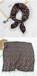 Detail of floral print silk scarf in black with red flowers on a minimalist background