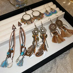 Five pairs of Bohemian fringe and feather earrings set in vintage ethnic beaded style